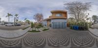 there is a spherical photo of a home in a suburban neighborhood, as seen from the intersection with a building