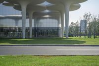 an open area has many flowers on it, including a green lawn and grass that leads to the building