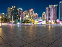 a city view at dusk looking toward a park with fountains and buildings in the background