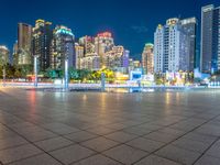 a city view at dusk looking toward a park with fountains and buildings in the background