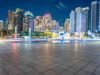 a city view at dusk looking toward a park with fountains and buildings in the background