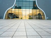 a building with a long glass door that leads to another building, which has stairs, and large windows