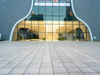 a building with a long glass door that leads to another building, which has stairs, and large windows