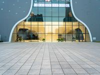 a building with a long glass door that leads to another building, which has stairs, and large windows