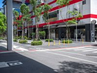 the tree lined streets around a tall building are lined with trees and plants, along with bright red accents