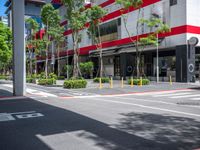 the tree lined streets around a tall building are lined with trees and plants, along with bright red accents