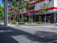 the tree lined streets around a tall building are lined with trees and plants, along with bright red accents