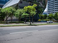 a van parked on the side of a road next to tall buildings and trees in a city