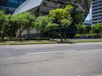 a van parked on the side of a road next to tall buildings and trees in a city