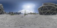 a view of some buildings in a circle of pebbles with a lot of trees in the background