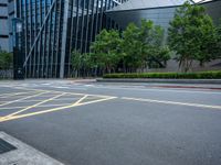 a parking lot with a building on the side of it and trees on the corner