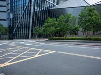 a parking lot with a building on the side of it and trees on the corner