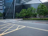 a parking lot with a building on the side of it and trees on the corner