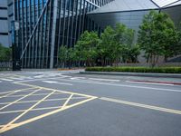 a parking lot with a building on the side of it and trees on the corner