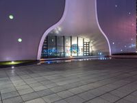 a building that looks like it has a huge arch shaped window and a small glass pool