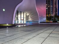 a building that looks like it has a huge arch shaped window and a small glass pool