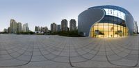 a building with a circular, abstract design in it and city buildings in the background