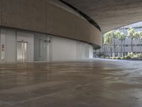 an empty building with doors and multiple levels that has a ramp on the side and lots of palm trees