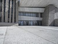 an empty square in the middle of a building with a white roof and gray pillars