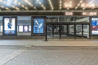 an outdoor picture of a theater at night with a building lit up in the background