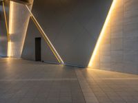 a hallway with columns on the wall that have led lights coming out of them and a door is behind the wall