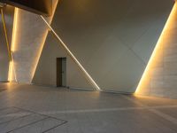 a hallway with columns on the wall that have led lights coming out of them and a door is behind the wall