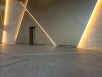 a hallway with columns on the wall that have led lights coming out of them and a door is behind the wall