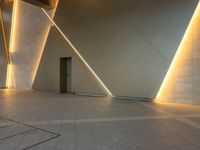 a hallway with columns on the wall that have led lights coming out of them and a door is behind the wall