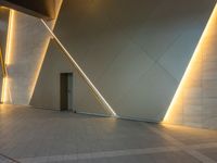 a hallway with columns on the wall that have led lights coming out of them and a door is behind the wall