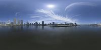 the city skyline sits behind a body of water with a ferry passing by it in front of the large city