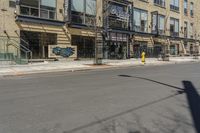 the street is empty at an intersection with the building behind it's glass front doors