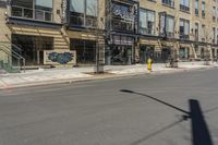 the street is empty at an intersection with the building behind it's glass front doors