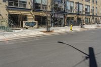 the street is empty at an intersection with the building behind it's glass front doors