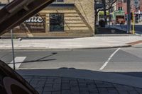 the front of a restaurant on a city street with a yellow car parked in front