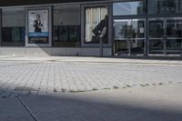 a person sitting at the bench in front of a mall that is empty of people