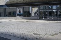 a person sitting at the bench in front of a mall that is empty of people