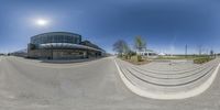 a small, curved circular photo in front of a building with stairs and grass area near the parking lot