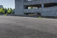 a concrete building sits at the top of a hill with concrete walls and pillars built over it