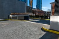 a parking lot with no cars on a sunny day next to tall buildings in the distance