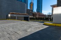 a parking lot with no cars on a sunny day next to tall buildings in the distance