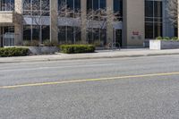 an empty city street with a fire hydrant next to it and a building with a few windows