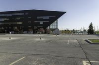 a parking lot near a large building has black paint on it and yellow lines on it