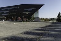 a parking lot near a large building has black paint on it and yellow lines on it