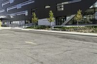 the front of the building has windows and a planter near the sidewalk on a side walk