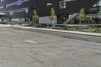 the front of the building has windows and a planter near the sidewalk on a side walk