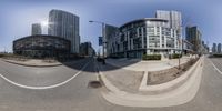 the reflection of buildings in a fisheye lens, shows an intersection in a city