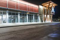 a store front at night with cars and lights outside it and the glass walls at the front