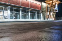 a store front at night with cars and lights outside it and the glass walls at the front