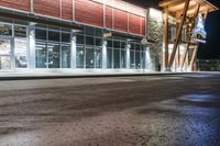 a store front at night with cars and lights outside it and the glass walls at the front