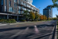 an empty street in a modern city with tall buildings in the background and blue sky above